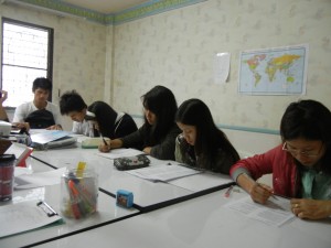Burmese students taking a practice GED test for sentence structure at BEAM Education Foundation.