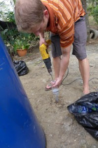 Drilling holes in the plastic bottles for a sustainable resource volunteer project.