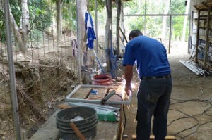 Welding the old metal desks for a sustainable resource volunteer project