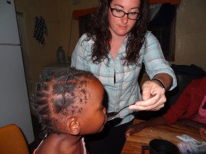 Giving Emely her medicine at Oz Kids Orphanage.